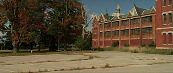 Movie still from “Session 9” (2001), directed by Brad Anderson – An old building with a tree in front of it; Extreme Wide shot, High angle