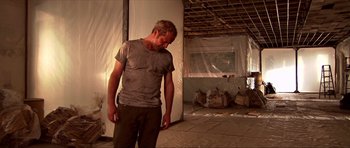 Movie still from “Session 9” (2001), directed by Brad Anderson – A man standing in the middle of a room under construction; Medium shot, Low angle
