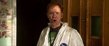 Movie still from “Session 9” (2001), directed by Brad Anderson – A man in a white jacket is making a funny face; Medium shot, Over the shoulder angle