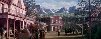 Movie still from “Seven Brides for Seven Brothers” (1954), directed by Stanley Donen – A painting of an old western town with horses and carriages; Extreme Wide shot, Low angle