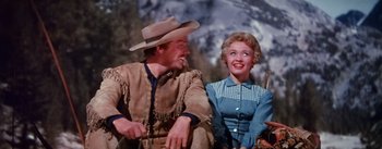Movie still from “Seven Brides for Seven Brothers” (1954), directed by Stanley Donen – A man and a woman sitting next to each other; Medium shot, Low angle