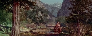 Movie still from “Seven Brides for Seven Brothers” (1954), directed by Stanley Donen – A painting of two people riding a horse drawn carriage in the mountains; Extreme Wide shot, High angle