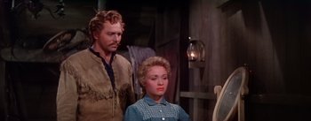 Movie still from “Seven Brides for Seven Brothers” (1954), directed by Stanley Donen – A man standing next to a woman in a room; Medium shot, Over the shoulder angle
