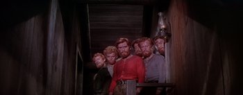 Movie still from “Seven Brides for Seven Brothers” (1954), directed by Stanley Donen – A group of men standing next to each other in a room; Medium shot, Low angle