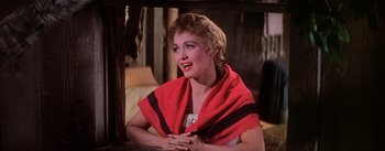 Movie still from “Seven Brides for Seven Brothers” (1954), directed by Stanley Donen – A woman with a red and black scarf around her neck; Close Up shot, Low angle