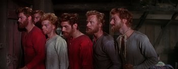 Movie still from “Seven Brides for Seven Brothers” (1954), directed by Stanley Donen – A group of men standing next to each other; Medium shot, Low angle