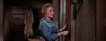 Movie still from “Seven Brides for Seven Brothers” (1954), directed by Stanley Donen – A woman painting a wall with a paint brush; Medium shot, Low angle