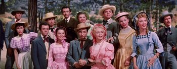 Movie still from “Seven Brides for Seven Brothers” (1954), directed by Stanley Donen – A group of people standing next to each other; Medium shot, Low angle