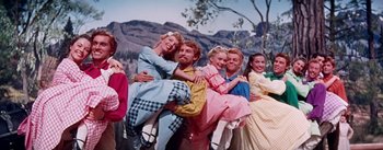 Movie still from “Seven Brides for Seven Brothers” (1954), directed by Stanley Donen – A group of people dressed in period clothing; Wide shot, Low angle