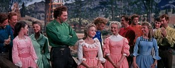 Movie still from “Seven Brides for Seven Brothers” (1954), directed by Stanley Donen – A group of people standing next to each other; Medium shot, Low angle