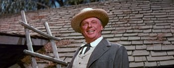 Movie still from “Seven Brides for Seven Brothers” (1954), directed by Stanley Donen – A man wearing a suit and a straw hat; Close Up shot, Low angle