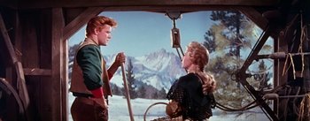 Movie still from “Seven Brides for Seven Brothers” (1954), directed by Stanley Donen – A man and a woman are standing in the snow; Medium shot, Low angle