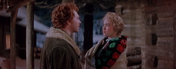 Movie still from “Seven Brides for Seven Brothers” (1954), directed by Stanley Donen – A man and a woman standing next to each other; Medium shot, Over the shoulder angle