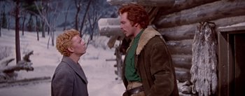 Movie still from “Seven Brides for Seven Brothers” (1954), directed by Stanley Donen – A man and a woman standing next to each other in the snow; Medium shot, Over the shoulder angle