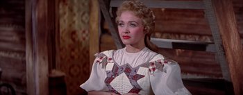 Movie still from “Seven Brides for Seven Brothers” (1954), directed by Stanley Donen – A woman in a white dress with a quilt pattern on it; Close Up shot, Over the shoulder angle