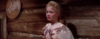 Movie still from “Seven Brides for Seven Brothers” (1954), directed by Stanley Donen – A woman in a white dress with a star on it's chest; Close Up shot, Over the shoulder angle