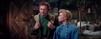 Movie still from “Seven Brides for Seven Brothers” (1954), directed by Stanley Donen – A man and a woman standing next to each other; Medium shot, Low angle