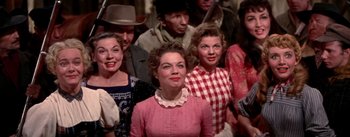 Movie still from “Seven Brides for Seven Brothers” (1954), directed by Stanley Donen – A group of people that are standing up together; Medium shot, Low angle