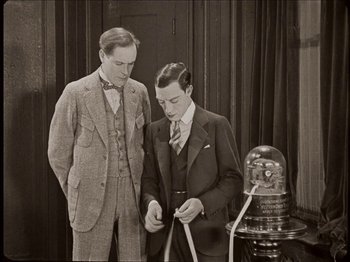 Movie still from “Seven Chances” (1925), directed by Buster Keaton – Two men in suits looking at an object in front of them; Medium shot, Low angle