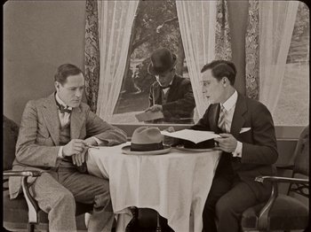 Movie still from “Seven Chances” (1925), directed by Buster Keaton – A group of men sitting at a table with papers; Medium shot, High angle