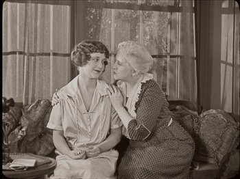 Movie still from “Seven Chances” (1925), directed by Buster Keaton – An old photo of two women sitting on a couch; Medium shot, High angle