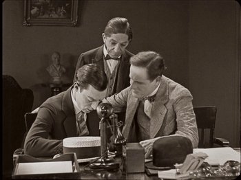 Movie still from “Seven Chances” (1925), directed by Buster Keaton – A group of men sitting around a table; Medium shot, High angle