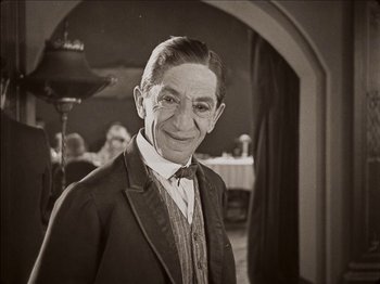 Movie still from “Seven Chances” (1925), directed by Buster Keaton – An older man wearing a suit and a bow tie; Close Up shot, High angle