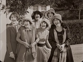 Movie still from “Seven Chances” (1925), directed by Buster Keaton – A black and white photo of a group of people wearing hats; Medium shot, Low angle