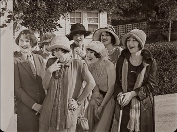 Movie still from “Seven Chances” (1925), directed by Buster Keaton – A group of people standing next to each other wearing hats; Medium shot, Low angle