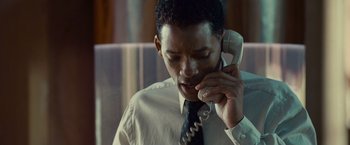 Movie still from “Seven Pounds” (2008), directed by Gabriele Muccino – A man talking on a phone while wearing a suit and tie; Close Up shot, Low angle