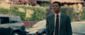 Movie still from “Seven Pounds” (2008), directed by Gabriele Muccino – A man in a suit and tie standing in front of a car; Medium shot, Over the shoulder angle