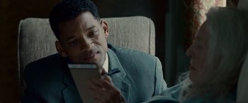 Movie still from “Seven Pounds” (2008), directed by Gabriele Muccino – A person sitting in a chair holding a tablet; Close Up shot, Over the shoulder angle
