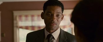 Movie still from “Seven Pounds” (2008), directed by Gabriele Muccino – A man wearing a suit and tie in front of a window; Close Up shot, Over the shoulder angle