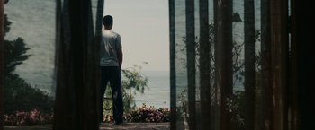 Movie still from “Seven Pounds” (2008), directed by Gabriele Muccino – A man looking out at the water from a deck; Wide shot, Low angle