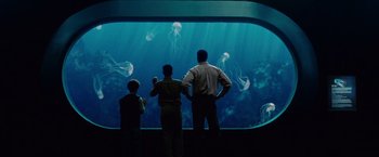 Movie still from “Seven Pounds” (2008), directed by Gabriele Muccino – A group of people standing in front of an aquarium; Wide shot, Low angle