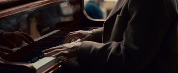 Movie still from “Seven Pounds” (2008), directed by Gabriele Muccino – A person playing a piano in a room; Extreme Close Up shot, High angle