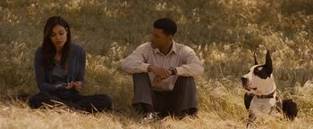 Movie still from “Seven Pounds” (2008), directed by Gabriele Muccino – A man sitting in the grass looking at his watch; Medium shot, Over the shoulder angle
