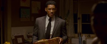 Movie still from “Seven Pounds” (2008), directed by Gabriele Muccino – A man wearing a suit and tie holding a box; Medium shot, Over the shoulder angle