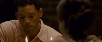 Movie still from “Seven Pounds” (2008), directed by Gabriele Muccino – A person with a lit candle; Close Up shot, Over the shoulder angle
