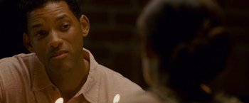 Movie still from “Seven Pounds” (2008), directed by Gabriele Muccino – A person sitting in a room; Close Up shot, Over the shoulder angle