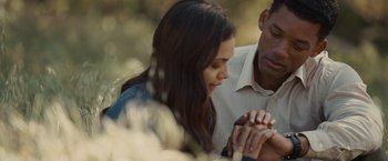 Movie still from “Seven Pounds” (2008), directed by Gabriele Muccino – A man and a woman holding hands in a field; Close Up shot, Over the shoulder angle