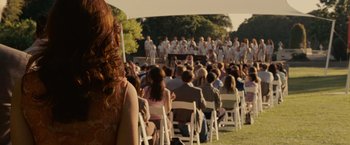 Movie still from “Seven Pounds” (2008), directed by Gabriele Muccino – A crowd of people sitting in chairs in a field; Medium shot, Over the shoulder angle