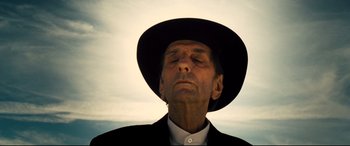 A man in a black hat and a white shirt