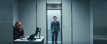 Movie still from “Severance” (2022), created by Dan Erickson – A man in a suit standing in an elevator; Wide shot, Low angle