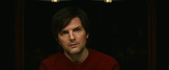 Movie still from “Severance” (2022), created by Dan Erickson – A person wearing a red shirt; Close Up shot, Over the shoulder angle