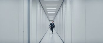Movie still from “Severance” (2022), created by Dan Erickson – A man in a suit and tie in an office hallway; Wide shot, Low angle