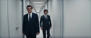 Movie still from “Severance” (2022), created by Dan Erickson – Two men in suits walking down a long hallway; Medium shot, Low angle