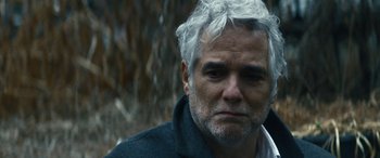 Movie still from “Severance” (2022), created by Dan Erickson – An older man with white hair looking at the camera; Close Up shot, Over the shoulder angle