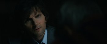 Movie still from “Severance” (2022), created by Dan Erickson – A person wearing a suit and tie; Close Up shot, Over the shoulder angle