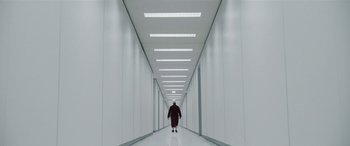 Movie still from “Severance” (2022), created by Dan Erickson – A man in a red suit walks down a long hallway; Extreme Wide shot, Low angle